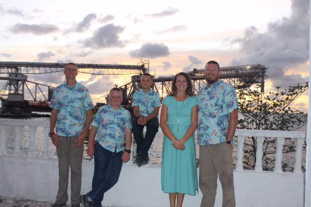 The McGeorge family on a seawall in Nauru with the phosphate loading cantilevers behind them